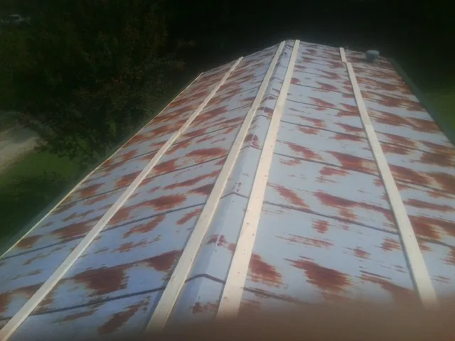 Rusted metal roof panels with new wood purlins before replacement — Storm Damage Roof Repair in Bokchito by Roofing Brothers
