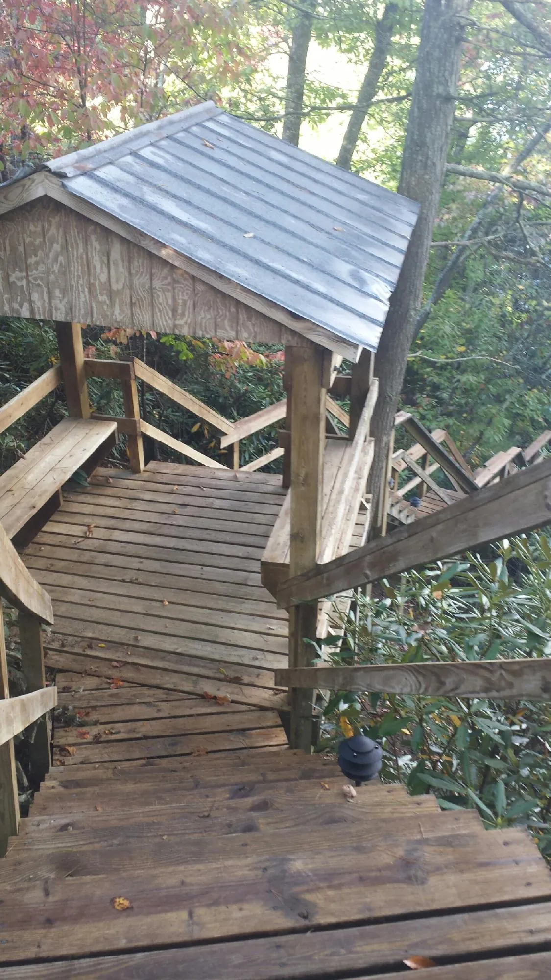 Metal roofed shelter over wooden steps on a wooded walkway — Skylight Repair & Installation work by our crew in Bokchito