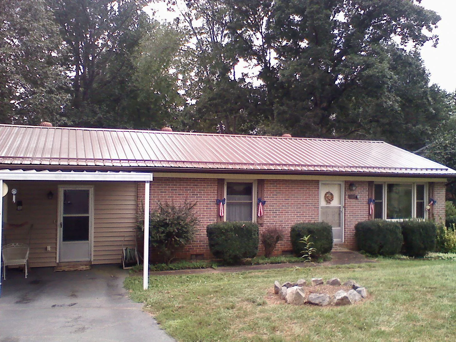 Bronze metal roof and carport on a brick ranch home — Roof Repair work by our crew in Bokchito