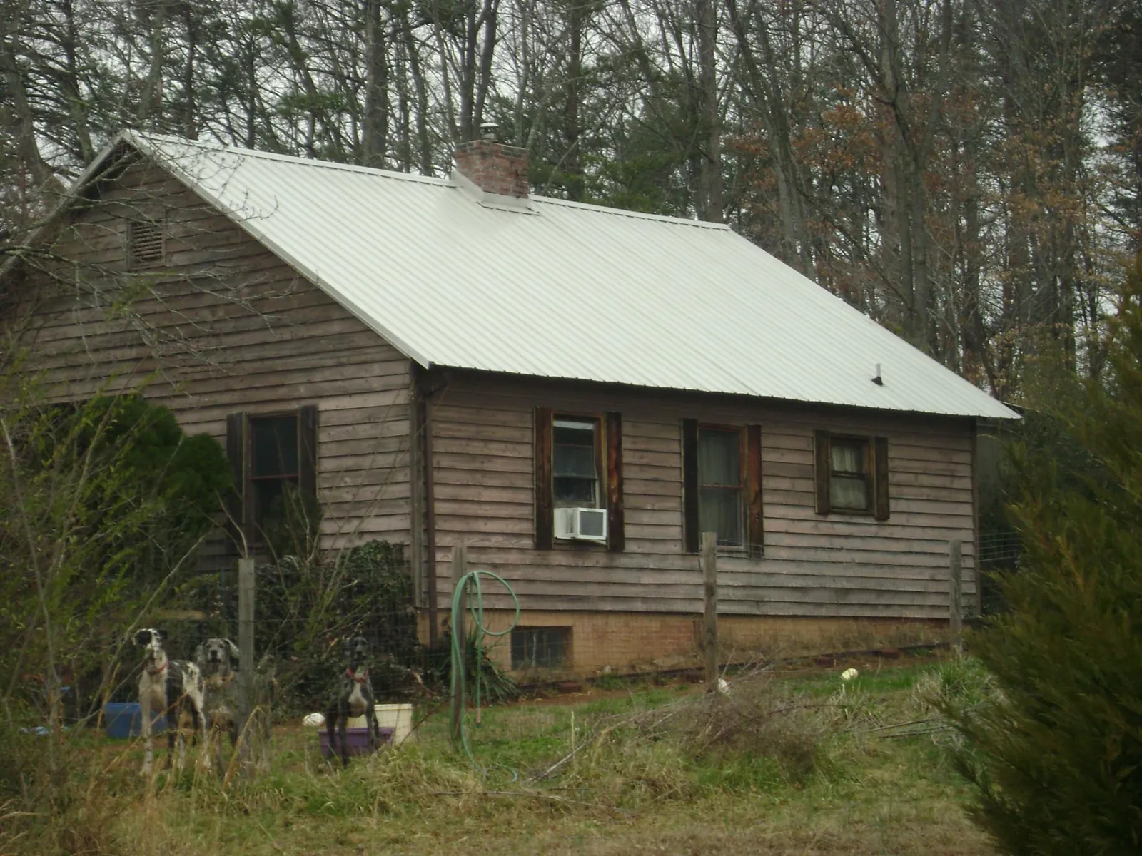 White metal roof on an old wood sided farmhouse, from a Asphalt Shingle Roof Repair job in Bokchito